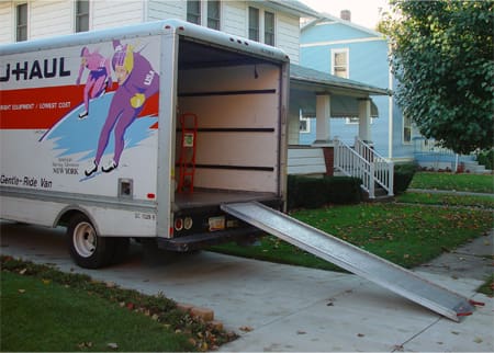 A moving truck with the door open and ramp down.