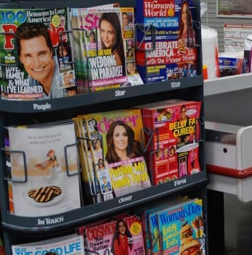 Here's an alt tag for the image: `Magazine rack with celebrity gossip magazines`