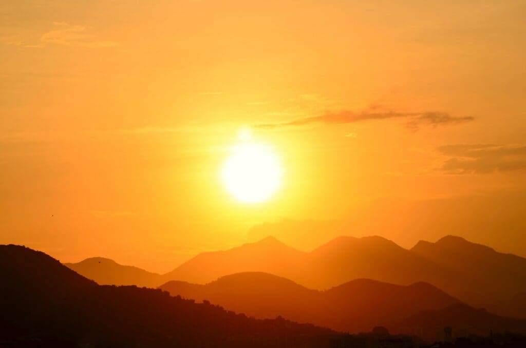 Sunset over silhouetted mountains.