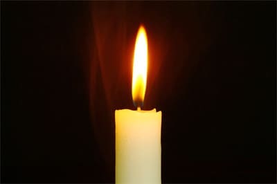 Single candle flame in darkness.