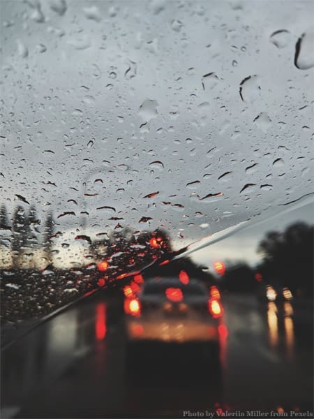 Rainy windshield, blurry traffic lights.