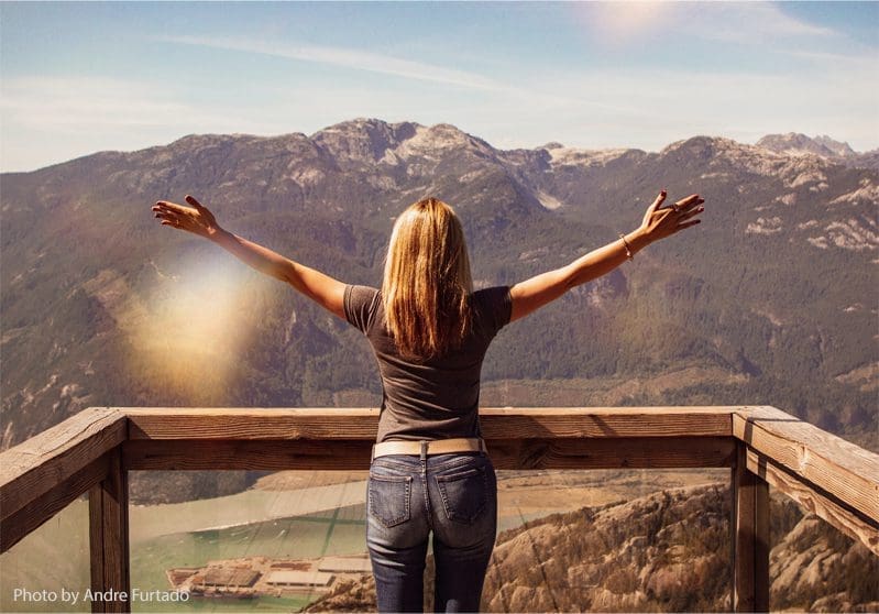 Woman enjoying mountaintop view.