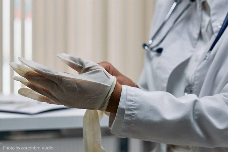 Doctor putting on medical gloves.