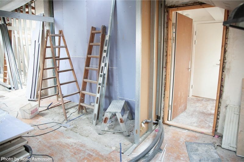 Room under renovation with ladders and tools.