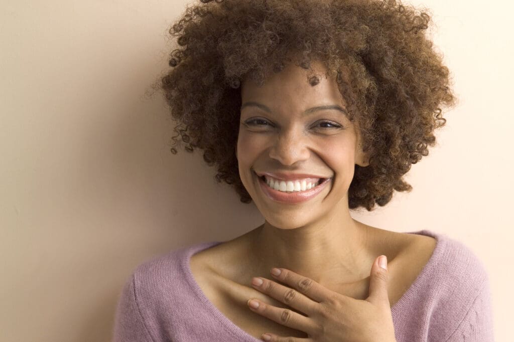 Happy woman with curly hair smiling.