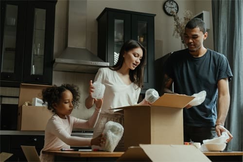 Family unpacking boxes in new home.