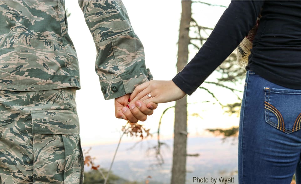 Couple holding hands, engagement ring.