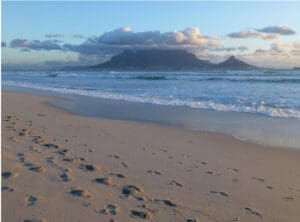 Beach with footprints and distant mountains.