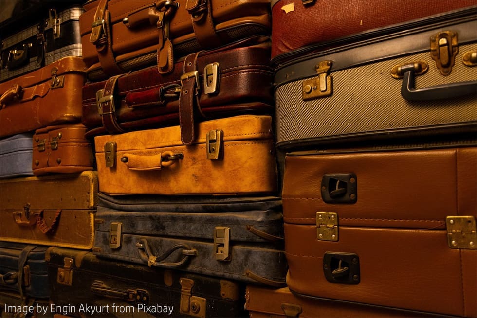 Stacked vintage suitcases in various colors.