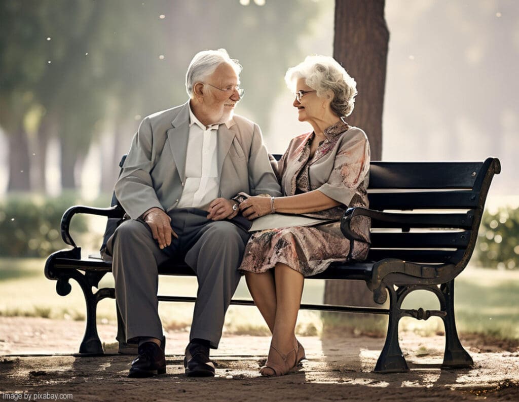 Elderly couple sitting on a park bench.